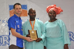 (L-R) Sebastine Bonjean, Head, Logistics, Promasidor Nigeria Limited; presenting the Long Service award to Adeyemo Nathaniel for having worked with the company for 15 years while his wife looks on at the ceremony held at the company’s headquarters in Lagos on Saturday