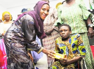 L-R: Executive Director, Dangote Group, Halima Aliko Dangote; presenting the grant to a physically challenged beneficiary, Kaosara Fagbemi from Surulere, during The Official flag-off of the Dangote Foundation Micro Grant Scheme for Women in LGAS/LCDAS on Thursday, 26th May, 2016 in Lagos